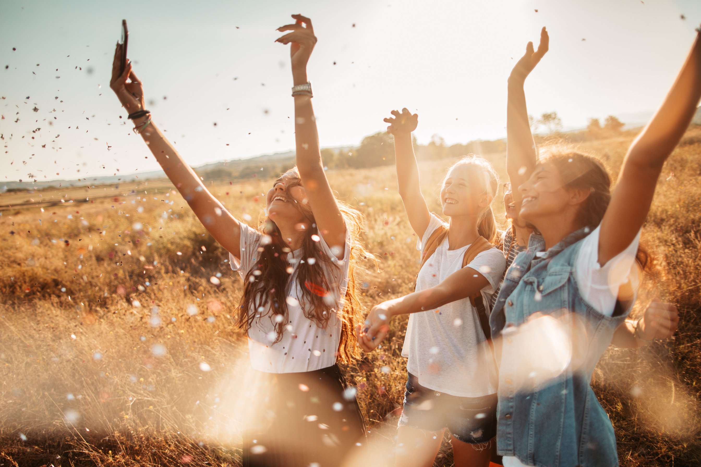 Girlfriends throwing confetti outdoors